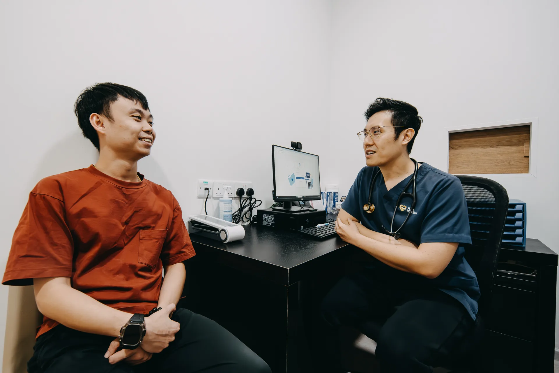 Dr Joel Foo in consultation with a male patient at his Singapore clinic
