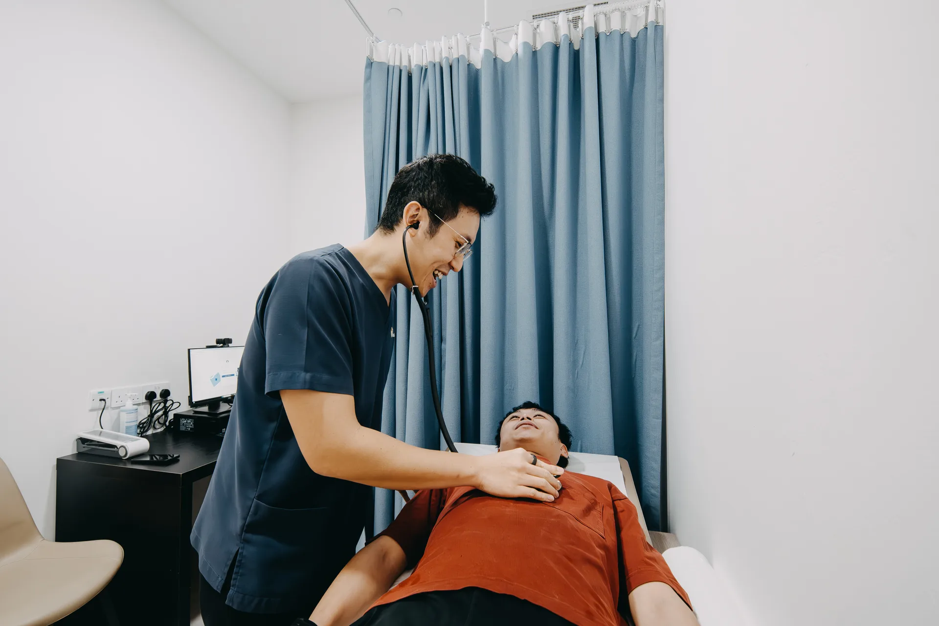 Dr Joel Foo performing a physical examination on a male patient at his Singapore clinic